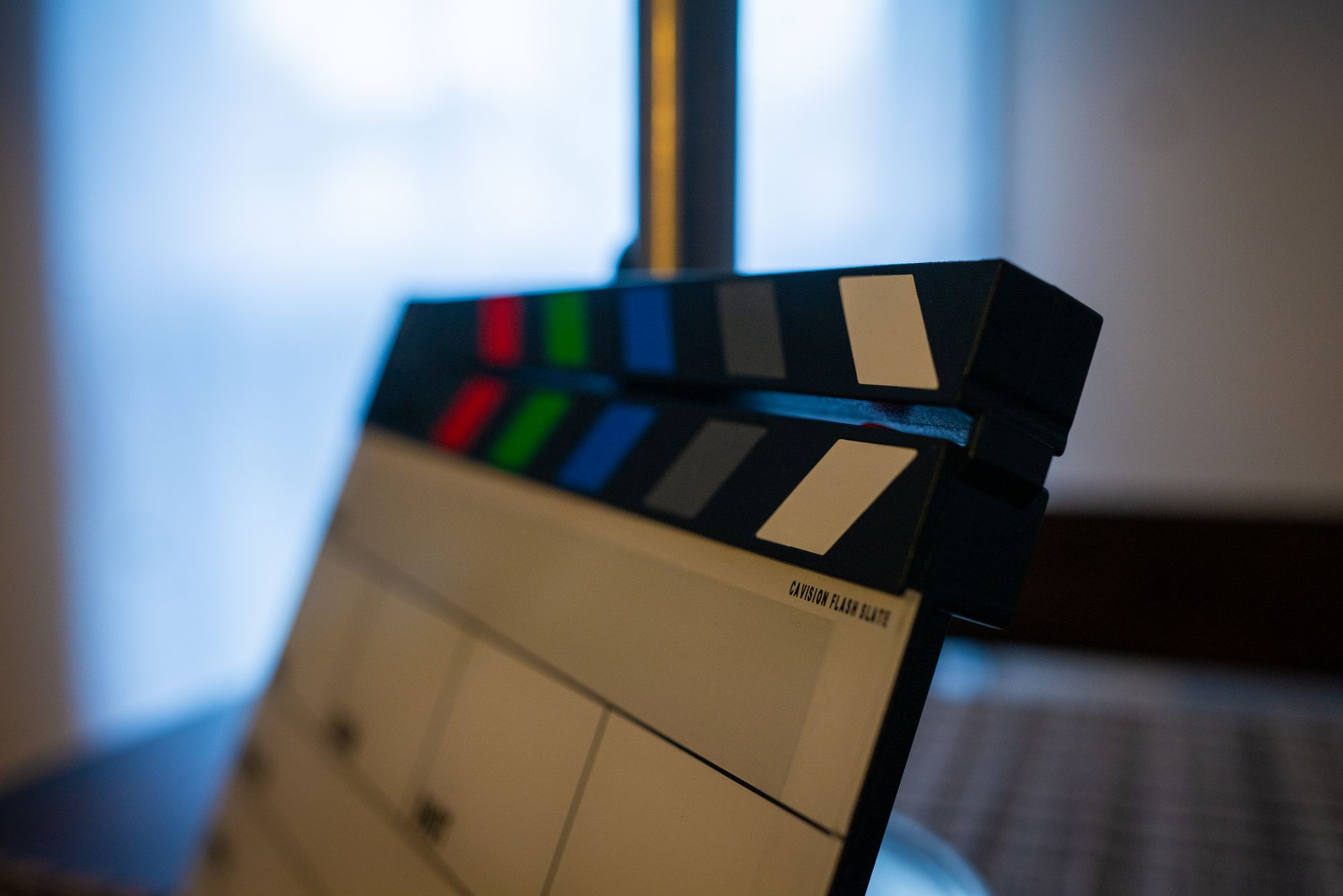 Filmklappe mit bunten Sync-Markierungen close-up vor unscharfem Hintergrund