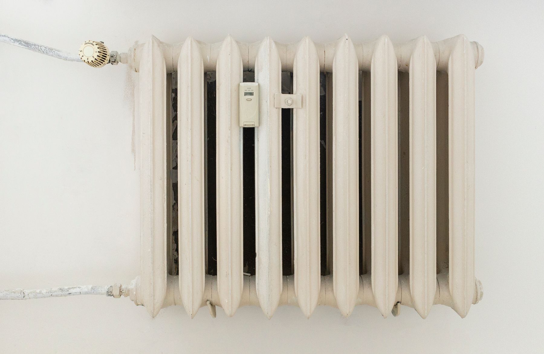 Klassischer weißer Heizkörper an einer hellen Wand in einem minimalistisch eingerichteten Raum