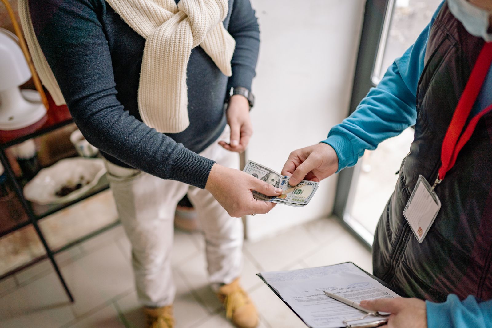 Hände tauschen Bargeld bei einer informellen Transaktion aus – Symbol für Schwarzarbeit