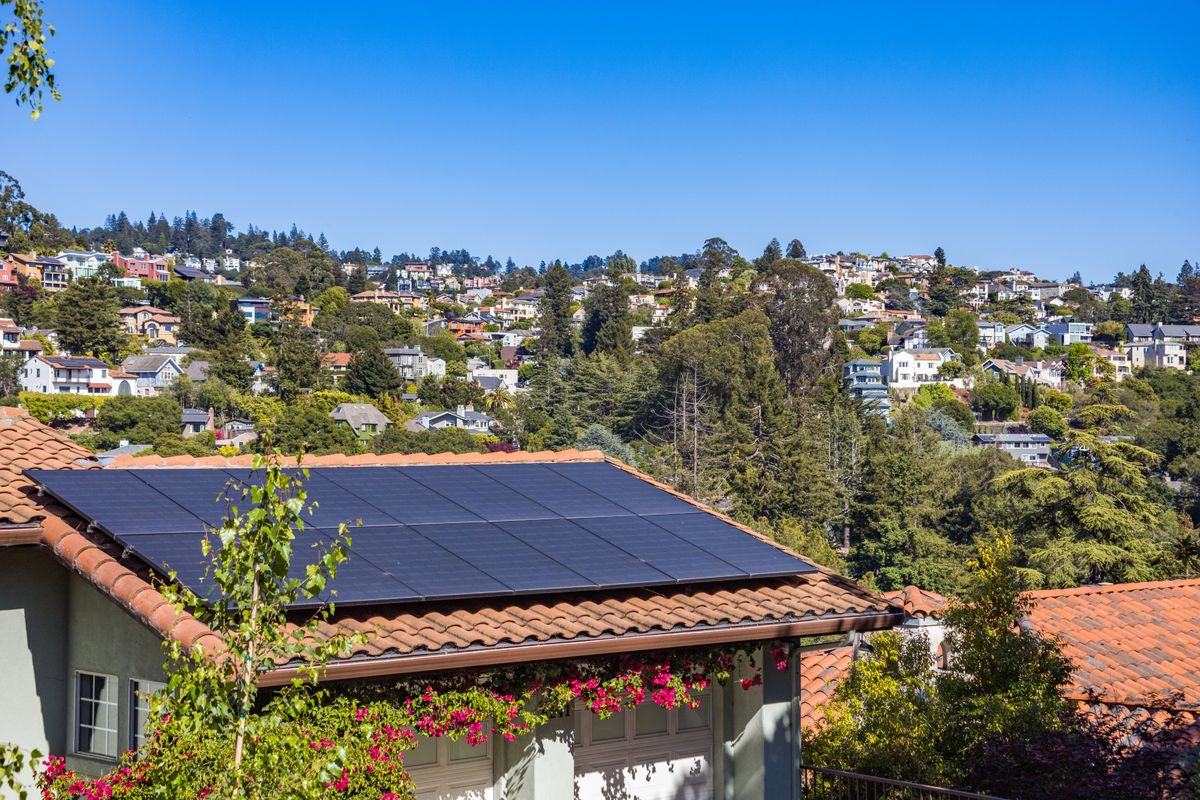 Einfamilienhaus mit Photovoltaikanlage auf dem Dach bei sonnigem Wetter