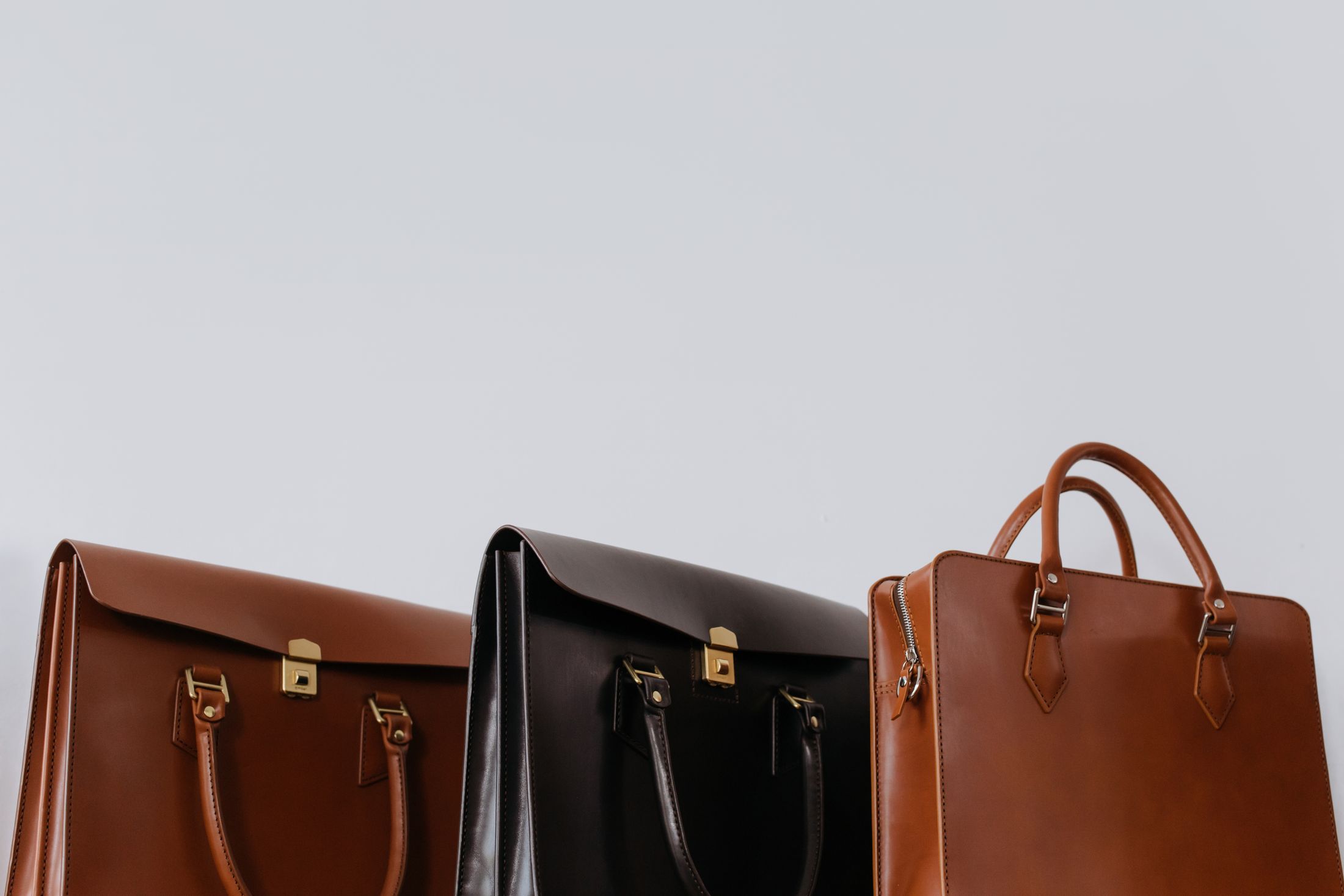 Drei elegante Ledertaschen in Braun- und Schwarztönen in Nahaufnahme