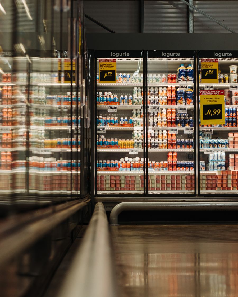 Gekühltes Supermarktregal mit dicht gestapelten Molkereiprodukten